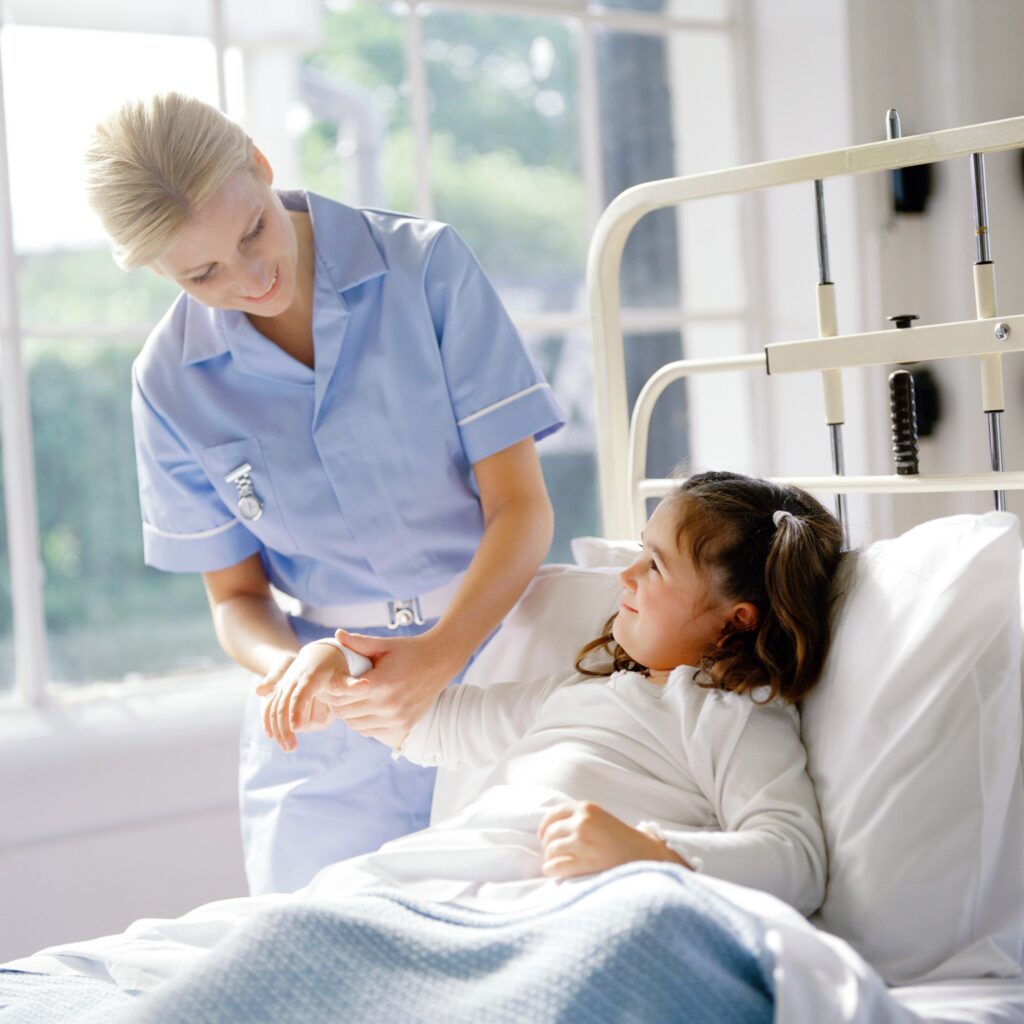 Portret młodej pielęgniarki sprawdzającej puls małej dziewczynki w łóżku