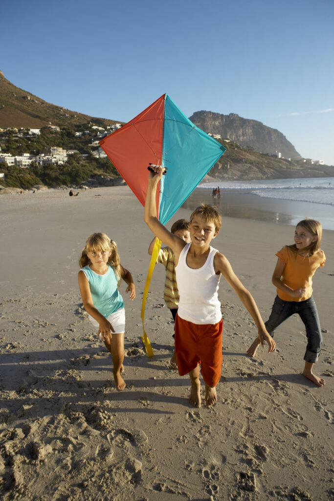 Grupa dzieci biegająca z latawcem