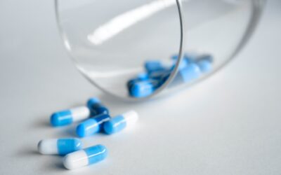 Biało niebieskie tabletki wysypywane ze szklanki